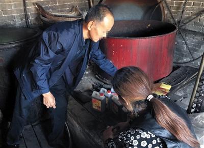 2018年10月1日，平遥县娃留村，酿醋作坊老板王金龙正在为食醋贴上自家的标签，他说原本2元一斤的廉价醋被古城醋商包装后，可以卖到近百元。