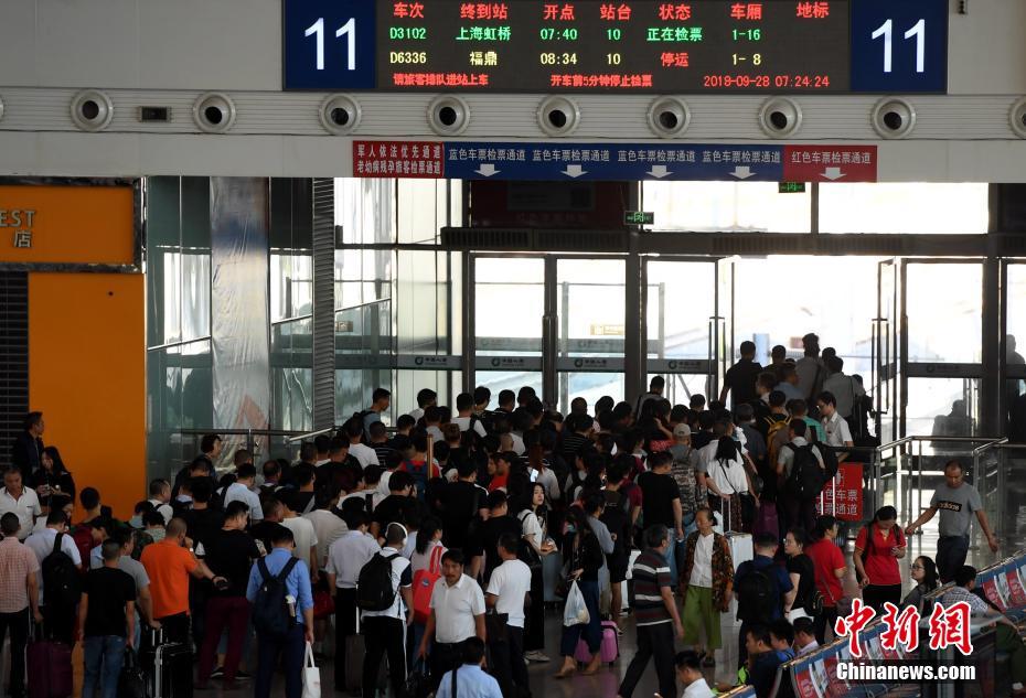 9月28日,出行的旅客在福州火车站排队进站上车.